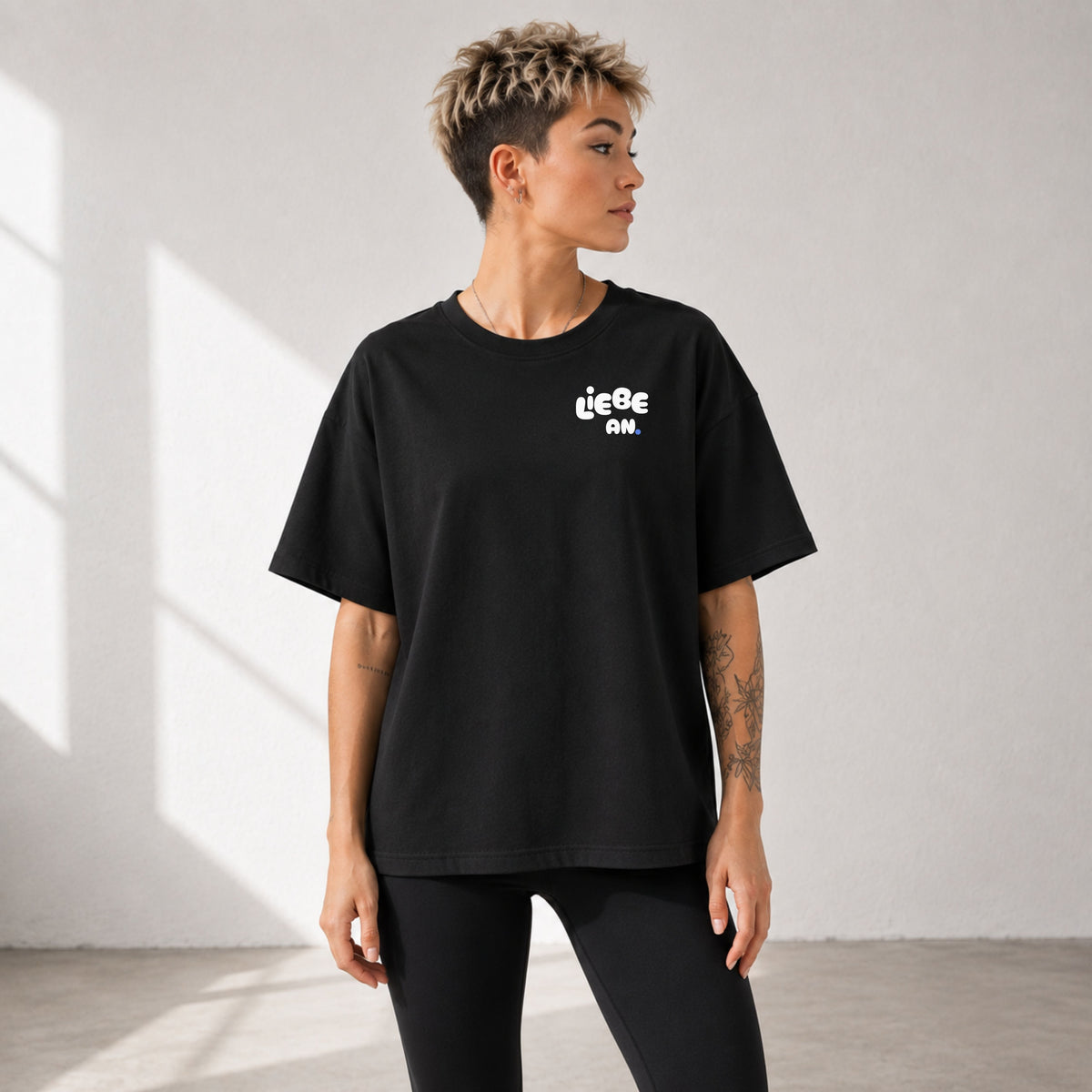     Frau im schwarzen Oversized Statement Shirt mit kleinem Brustmotiv