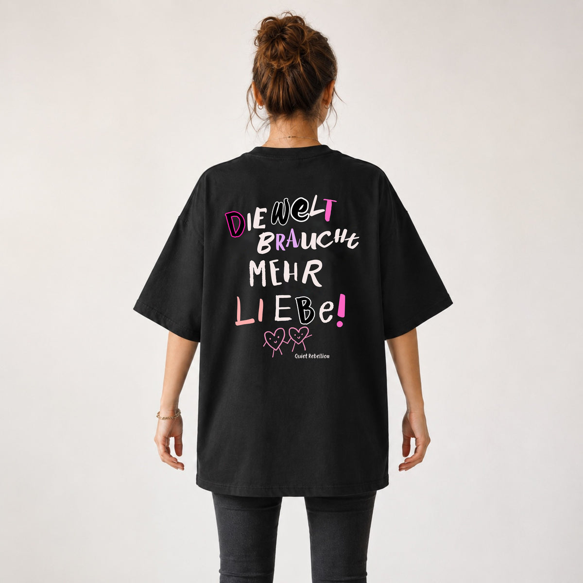 Frau von hinten im schwarzen Oversized Statement Shirt „Die Welt braucht mehr Liebe“